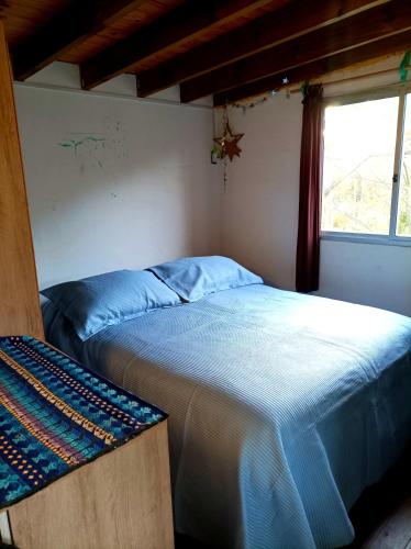 a bedroom with a bed and a window at Cabaña Pitiayumí in Villa Serrana