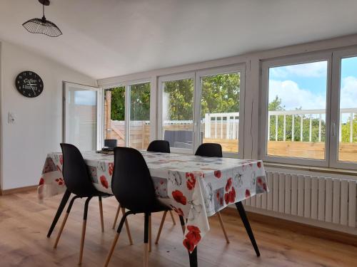 ラ・ロッシュ・シュル・ヨンにあるLogement lumineux avec terrasseのテーブルと椅子、窓のあるダイニングルーム