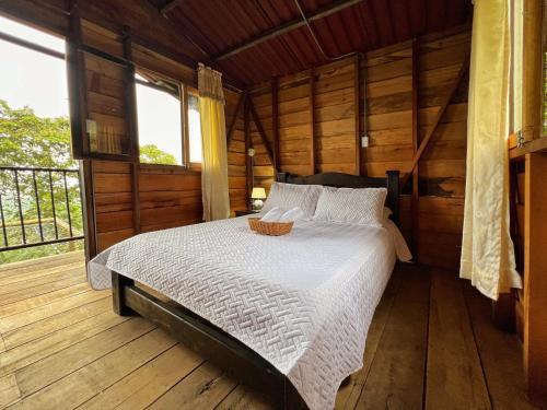 Un dormitorio con una cama en una habitación de madera. en Hospedaje Mirador La Aurora Filandia, en Filandia
