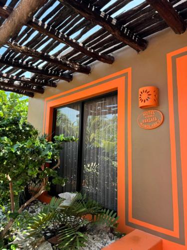 a house with an orange door on the side of it at Cabañas Manglares in Celestún