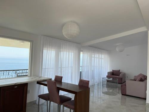 a living room with a table and chairs and a couch at Apartment Light House in Dobra Voda