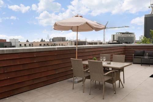 a table and chairs with an umbrella on a rooftop at Penthouse in City Center w Private Rooftop Terrace in Aarhus