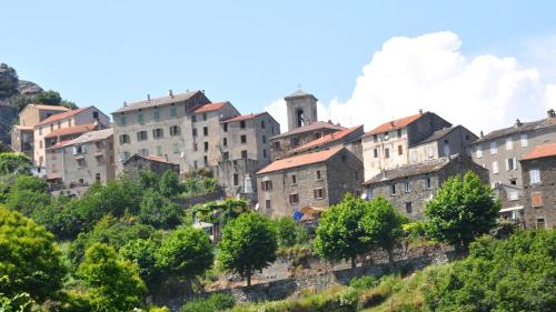 un groupe de bâtiments sur une colline plantée d'arbres dans l'établissement Villa Via Ferrata, à Canale-di-Verde