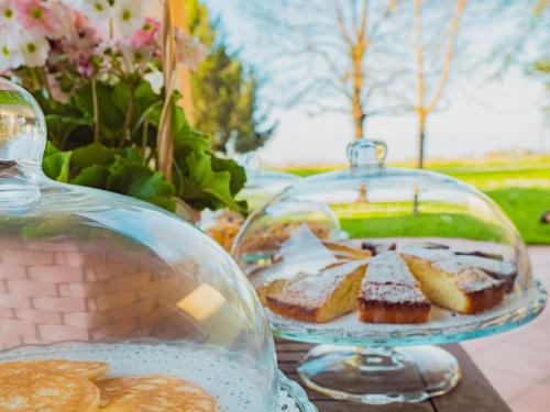 a table with a glass dish of pastries and cookies at B&B Villa Erika in Lugo