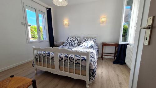 - une chambre dotée d'un lit blanc avec des oreillers bleus et blancs dans l'établissement Saint Georges de Didonne - QUARTIER IDEAL POUR SE RESSOURCER - MAISON rénovée, à Saint-Georges-de-Didonne