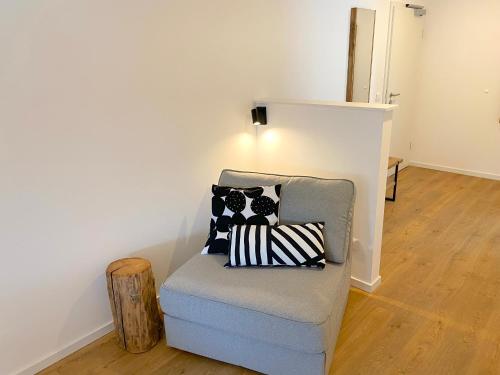 a chair with pillows on it in a room at Timmenhus - neue Ferienwohnungen im historischen Bauernhaus in Timmendorfer Strand