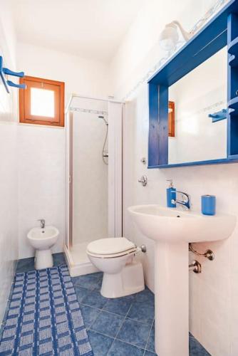 a bathroom with a sink and a toilet and a mirror at Casa vacanze Villa Raffaela in Favignana