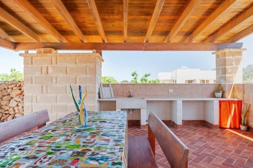 ファヴィニャーナにあるCasa vacanze Villa Raffaelaのダイニングテーブルと椅子付きのパティオ