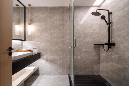 a bathroom with a glass shower and a sink at Palau Sunrise Seaview Landison Retreat in Melekeok