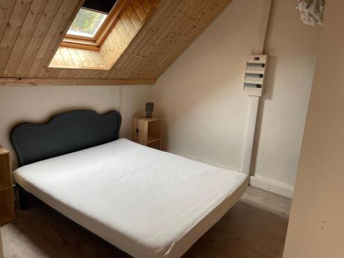 un lit dans une petite pièce avec une fenêtre dans l'établissement Appartement pour 8 personnes, à La Bourboule