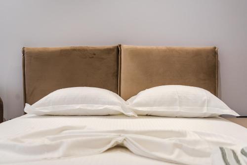 a bed with two white pillows and a brown headboard at SR Apartments Golem in Golem