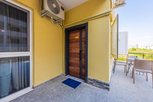 a balcony with a wooden door and a table and chairs at SR Apartments Golem in Golem