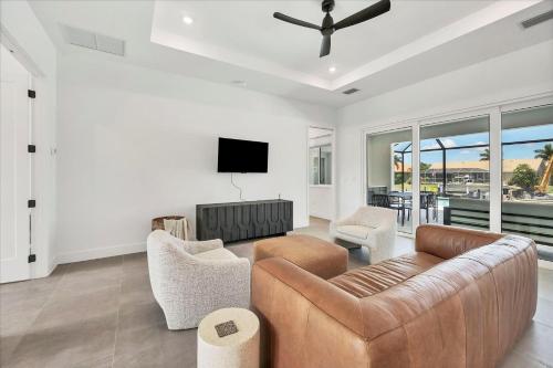 a living room with a couch and chairs and a tv at 509 Eleuthera in Punta Gorda