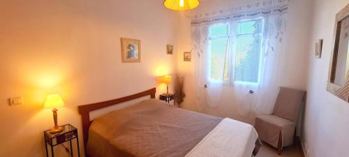 une chambre avec un lit, une fenêtre et une chaise dans l'établissement Villa A Sulana, à Canale-di-Verde