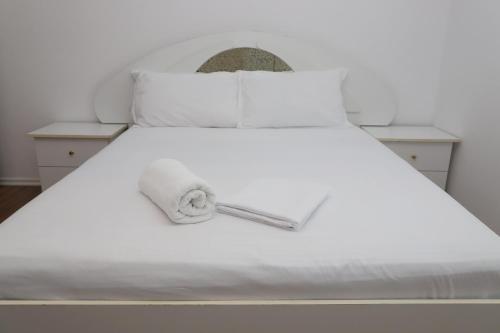 a white bed with white sheets and pillows at Villa Fjorentin Berat in Berat