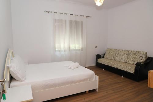 a white room with a bed and a couch at Villa Fjorentin Berat in Berat
