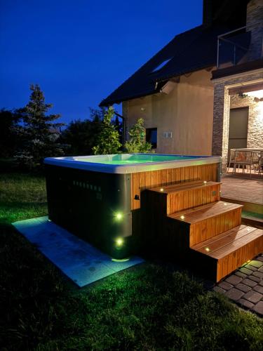 a hot tub in the backyard of a house with lights at Jaśminowy Dom in Mikołajki