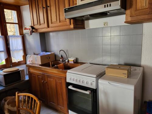 a kitchen with a stove top oven next to a sink at Maison de village in Silvareccio