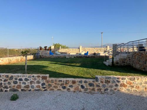 a stone wall with a yard with a playground at Cindy Luxury Villas Crete GR in Stavros