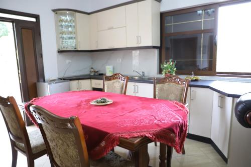 a kitchen with a table with a red table cloth on it at Villa Fjorentin Berat in Berat