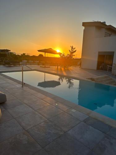 a swimming pool with the sunset in the background at Cindy Luxury Villas Crete GR in Stavros