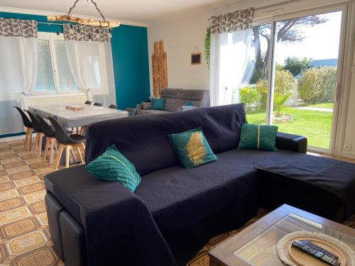 un salon avec un canapé bleu et une table dans l'établissement Gîte de L'Enclose La Barre de Monts 85, à La Barre-de-Monts