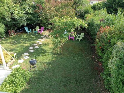 a garden with chairs and a grill in the grass at Chez Papinette, proche gare et centre, pdj compris in Niort