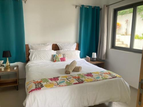 a bedroom with a bed with a stuffed animal on it at LnD Apartments - Le Morne - One Bedroom in La Gaulette