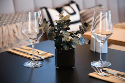 a table with two wine glasses and a vase with flowers at ESTIMAR Marina Farnals in Puebla de Farnals