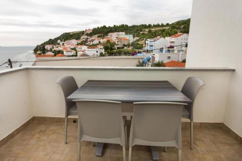 a table and chairs in a balcony with a view of the ocean at Holiday Home in Komarna