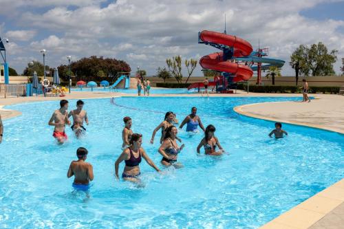 a group of people in a pool at a water park at Confort Apartment 2 Bedrooms in Alhos Vedros