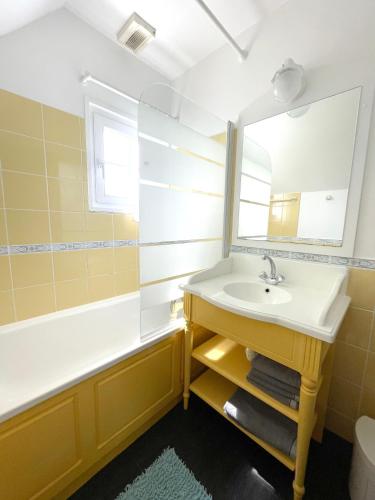 une salle de bain avec un lavabo et un miroir dans l'établissement H02, à Fort-Mahon-Plage