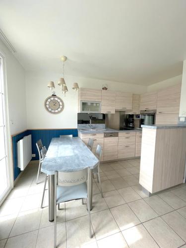 une cuisine avec une table et des chaises dans une pièce dans l'établissement H02, à Fort-Mahon-Plage