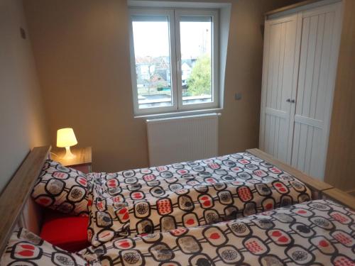 1 dormitorio con 2 camas y ventana en Bruges Brujas holiday house, en Brujas