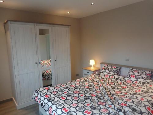 a bedroom with a bed with a comforter on it at Bruges Brujas holiday house in Bruges
