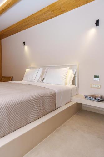 a white bed with white sheets and pillows at Halo Santorini - Living Experience in Fira
