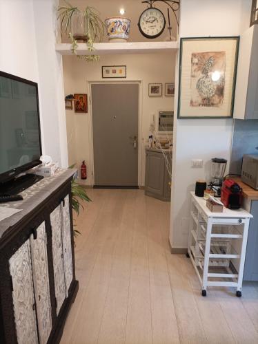 a living room with a flat screen tv and a table at Roma Casetta - Tourist Rooms in Guidonia