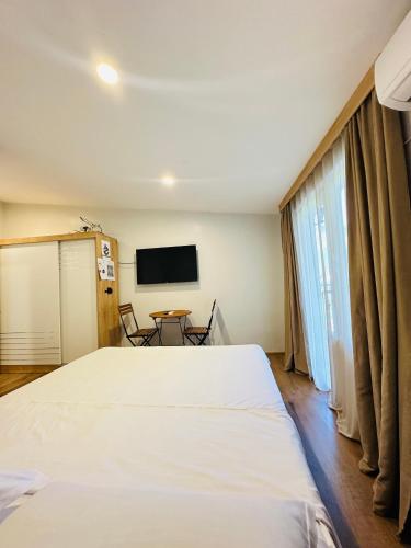 a bedroom with a large white bed and a table at Woodland Borjomi in Borjomi