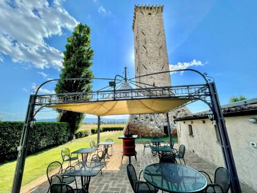 a patio with tables and chairs and a tower at Fab villa with fenced pool, huge grounds, meditation park, child activity park in Limiti
