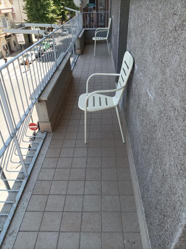 a white bench sitting on the side of a balcony at Roma Casetta - Tourist Rooms in Guidonia