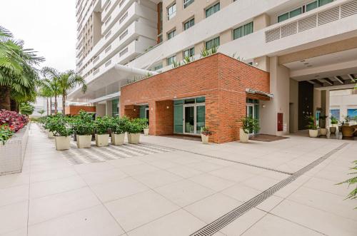 a courtyard of a building with potted plants at Lifespace Curitiba - Apartamentos UROOMS in Curitiba