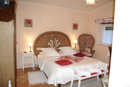 - une chambre avec un grand lit blanc et des oreillers rouges dans l'établissement Chambres d'hôtes La Téoulère, à Saint-Martin-Curton