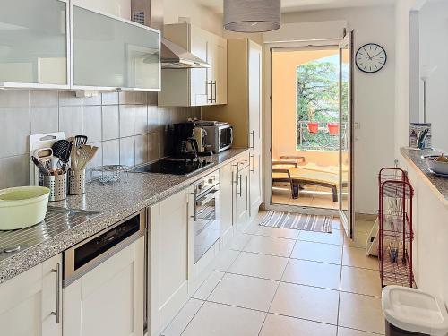 une cuisine avec des armoires blanches et un comptoir dans l'établissement 2 bedroom with pool 2 bathrooms 339, à Cannes