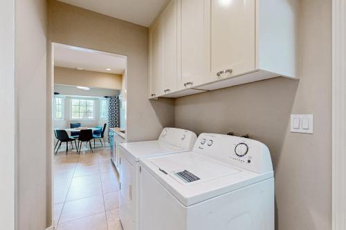 eine Waschküche mit einer Waschmaschine, einem Trockner und einem Tisch in der Unterkunft Movie Colony Bungalow Permit# 3364 in Palm Springs