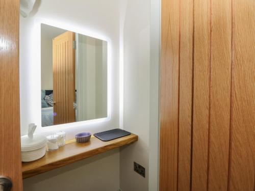 a bathroom with a mirror and a shelf with plates at Strawberry Cottage in Blairgowrie