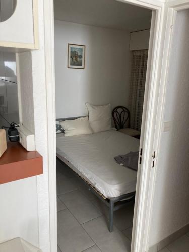 une petite chambre avec un lit dans une pièce dans l'établissement Cap d'Agde, au Cap d'Agde