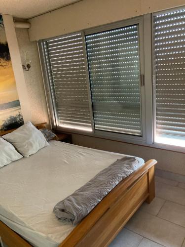 Ce lit se trouve dans un dortoir doté de 2 grandes fenêtres. dans l'établissement Cap d'Agde, au Cap d'Agde