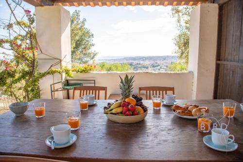 - une table en bois avec un bol de fruits et de jus d'orange dans l'établissement Villa Bonnard in Nice Sea and city View & Pool, à Nice