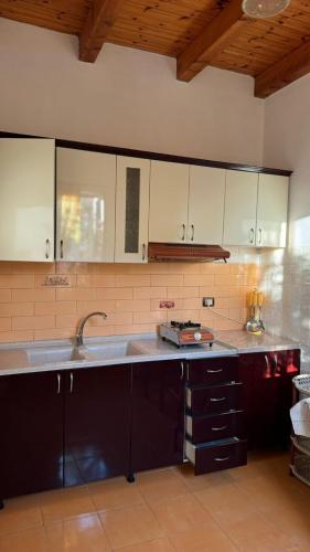 a kitchen with white cabinets and a sink at Guesthouse Bregdeti in Velipojë