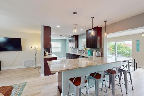 Una cocina con una gran isla con taburetes de bar. en Prize Catch, en Palm City